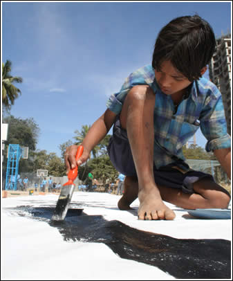 Boy from Born Free Art School paints on The World's Largest Love Letter. 